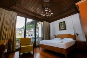 a bedroom with a bed and a large window at Hotel Onufri in Berat