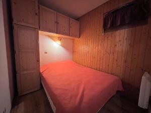 a small room with a bed with a red sheet at LA RESIDENCE 2-234 - Proche centre du village avec garage in La Clusaz