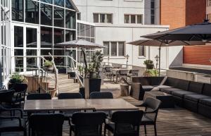 an outdoor patio with tables and chairs and umbrellas at Lapland Hotels Tampere in Tampere