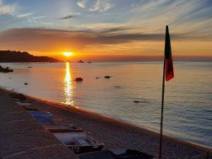 einen Sonnenuntergang über dem Wasser mit Booten am Strand in der Unterkunft Sole Mare B&B in Giardini-Naxos