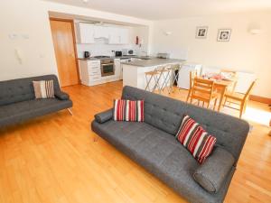 a living room with a couch and a kitchen at 15 Sovereign House in Milford Haven