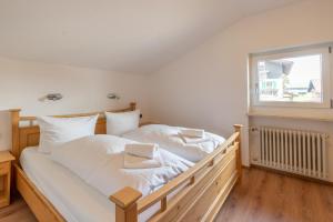 1 dormitorio con 1 cama con sábanas blancas y ventana en Schöne Aussicht, en Fischen