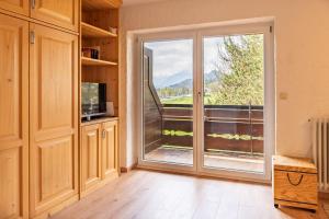 Habitación con puerta corredera de cristal y balcón. en Schöne Aussicht, en Fischen