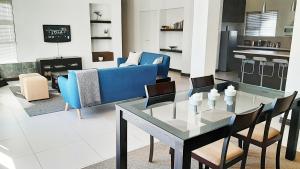 a living room with a glass table and chairs at Hadingham Russell Holiday House in Hermanus