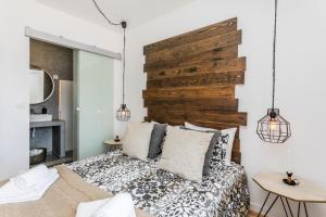 - une chambre avec un lit et une tête de lit en bois dans l'établissement Santo Estevão by SpotOn Apartments, à Lisbonne
