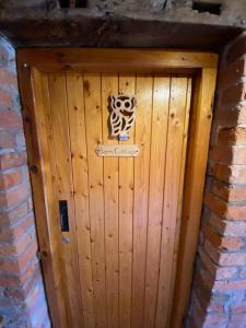 a wooden door in a brick wall with a sign on it at Bank Farm Cottages in Nantwich