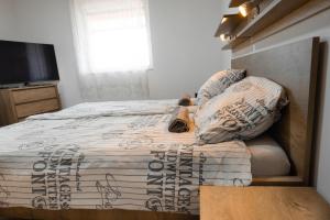 a bedroom with a bed and a television in it at Tenisz Vendégház in Ordacsehi