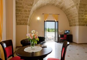 a living room with a table with a vase of flowers at Tenuta La Baronessa Resort in Tuglie