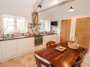 a kitchen with a wooden table in a kitchen at Edencroft in Penrith