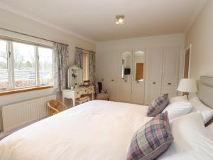 a bedroom with a white bed and a window at Edencroft in Penrith