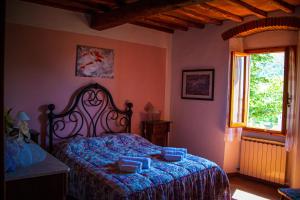 a bedroom with a bed with blue sheets and a window at Casa da Pietro in Poggio Alla Croce