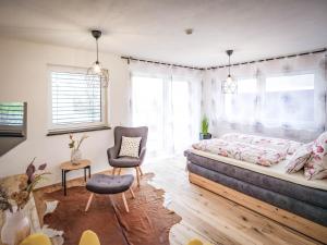 a bedroom with a bed and a chair at Apartments Frauensee in Reutte