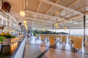 a restaurant with tables and chairs and a view of the ocean at Oasis Hotel in Perama