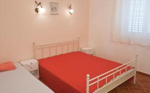 um quarto com uma cama com uma colcha vermelha em Apartment Parlov em Rogoznica
