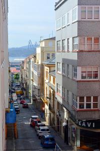 una calle de la ciudad con coches estacionados al lado de los edificios en Apartamento en centro de Ferrol, en Ferrol