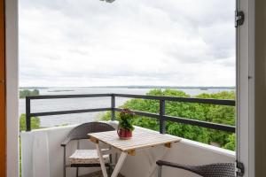 una mesa y sillas en un balcón con vistas al agua en Deluxe Quartier am Plöner See - Hallenbad kostenlos, en Plön