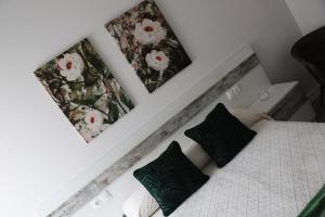 1 dormitorio con 1 cama y 2 cuadros en la pared en KASETAS APARTMENT’S, en Sarria