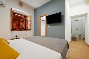 a bedroom with a white bed and a flat screen tv at TOMY - KATY in Trogir