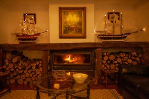 sala de estar con chimenea y 2 veleros en la pared en La Villa del Pantano, en Olmedilla de Alarcón