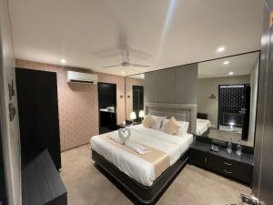 1 dormitorio con 1 cama grande y espejo grande en Gulf Hotel Mumbai- The Boutique Hotel Colaba Mumbai en Bombay