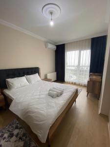 ein Schlafzimmer mit einem großen Bett mit zwei Handtüchern darauf in der Unterkunft Kıvanç Residence in Trabzon
