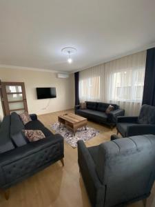 ein Wohnzimmer mit zwei Sofas und einem Fernseher in der Unterkunft Kıvanç Residence in Trabzon
