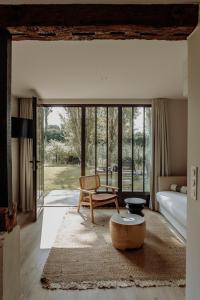 a room with a bed and a chair and a table at Les Manoirs des Portes de Deauville - Small Luxury Hotel Of The World in Deauville