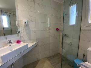 a bathroom with a sink and a shower at Angela Hotel & Apartments in Gouvia