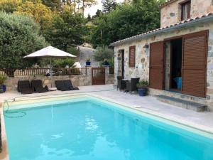 a swimming pool in a yard with a house at CHAMBRES DHOTES CORSE in Venaco
