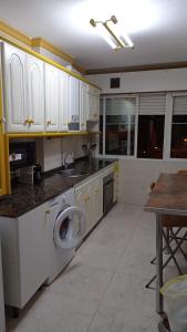 a kitchen with white cabinets and a washing machine at Piso centrico en Pravia, con 3 habitaciones sin ascensor in Pravia