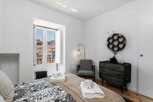 a bedroom with a bed and a dresser and a window at Santo Estevão by SpotOn Apartments in Lisbon