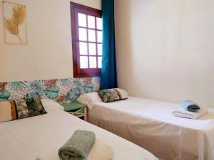 a room with two beds and a window at Cheap & Chic Apartamentos en Son Bou de 2 dormitorios in Son Bou +7 photos