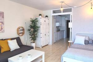 ein Wohnzimmer mit Sofa und Tisch in der Unterkunft Altagay, apartamento con impresionantes vistas al mar y a El Teide in Punta del Hidalgo