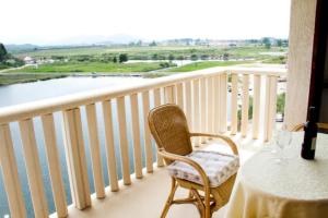 a table and a chair on a balcony with a view at Comfortable and beautiful apartment in Ploče