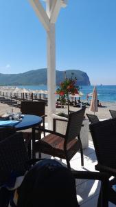 a patio with tables and chairs on the beach at Stone House in Buljarica in Petrovac na Moru