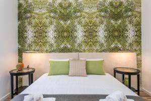 um quarto com uma cama com uma parede verde em São José by SpotOn Apartments em Lisboa
