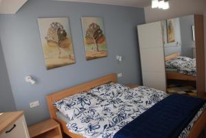 ein Schlafzimmer mit einem Bett und zwei Bildern an der Wand in der Unterkunft Apartamenty Darłówko in Darłówko