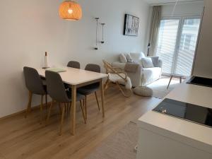 - un salon avec une table, des chaises et un canapé dans l'établissement Arctic City Nest, à Rovaniemi