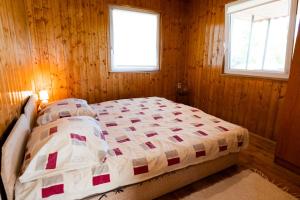 OrdacsehiにあるTennis Guesthouseの木製の部屋にベッド1台が備わるベッドルーム1室があります。