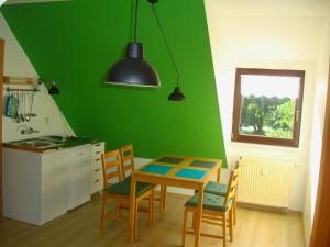 cocina con mesa y pared verde en Fewo-Rammenau Monteurunterkunft, en Rammenau