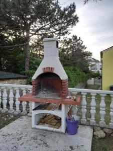 a brick oven sitting on top of a fence at Apartman BoloB in Baška
