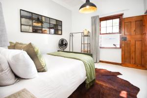 a bedroom with a white bed and a window at Videira-on-Mitchell in Riversdale