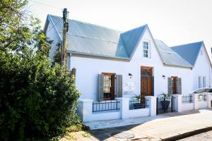 a white house with a blue roof at Videira-on-Mitchell in Riversdale