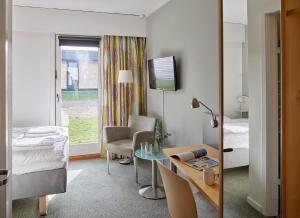 Habitación de hotel con cama, mesa y espejo en Huset Middelfart en Middelfart