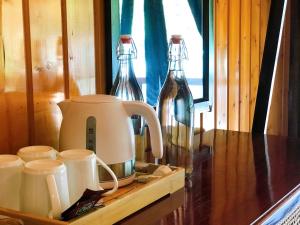 a counter with two glass bottles and a coffee maker at DONG VAN CLIFFSIDE HOUSE in Dồng Văn