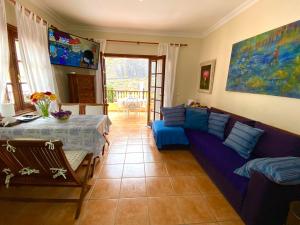 ガラチコにあるMaravilloso Apartamento VISTAS AL MAR Y VOLCANの紫色のソファとテーブル付きのリビングルーム
