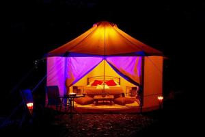 a tent with a bed in it at night at Paliouri Luxury Bungalows in Paliouri