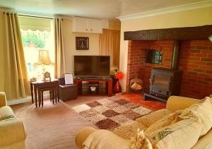 a living room with a fireplace and a tv at Fisherman's Cottage - The Ultimate Romantic Lakeside Cottage just a few steps from the Beach! Relax with a glass of wine & Snuggle up to the Cosy Log Burner at the BEST Location in Mablethorpe! It's Pet Friendly too! in Mablethorpe