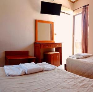 Pokój z 2 łóżkami i komodą z lustrem w obiekcie Maria's Beach Apartments w Sidari