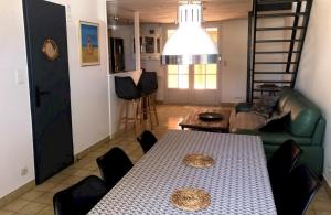 a living room with a table and a couch at Le Phare - Gîte de mer Boyardville in Boyard-Ville